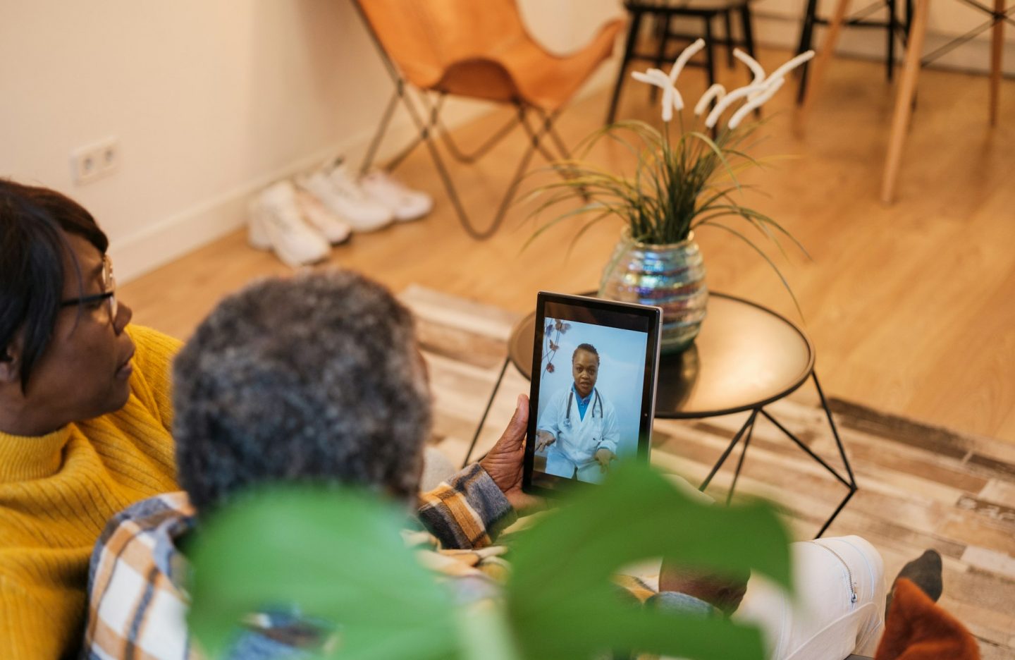 Senior couple attended by the doctor through the tablet through telehealth care.